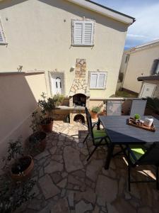 a patio with a table and a fire place at Holiday house Matej in Vir
