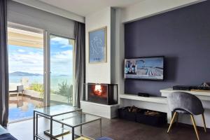 a living room with a fireplace and a view of the ocean at Blue Bay Suites in Myloi