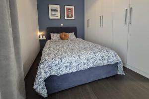 a bedroom with a bed with a teddy bear on it at Blue Bay Suites in Myloi