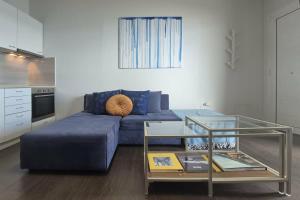 a living room with a blue couch and a table at Blue Bay Suites in Myloi