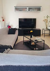 a living room with two beds and a television at Nàra house in Áyios Spirídhon
