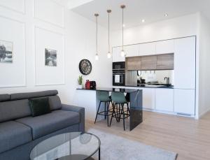 a living room with a couch and a kitchen at MONTE CARLO BORDER - exclusive & modern flat in Beausoleil +20 photos