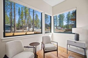 a living room with two chairs and a table and windows at 18163-2 Forestbrook Loop in Bend