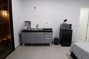 a kitchen with a sink and a microwave in a room at Studio III - Centro Jundiaí - Ar Condicionado in Jundiaí