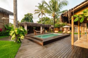an outdoor deck with a swimming pool and a house at Pousada D'Oxum Caraíva in Caraíva