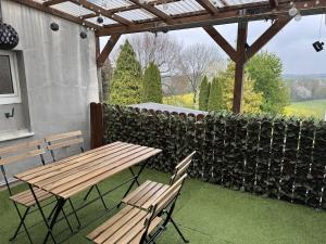 a wooden picnic table and chairs on a patio at 2BR, terrace, free parking in Leverkusen