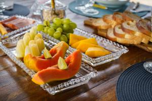 ein Tisch mit zwei Tabletts mit Obst und Brot in der Unterkunft Pousada Maré Búzios in Búzios