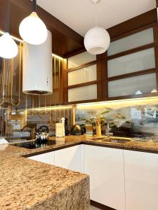 a kitchen with white cabinets and a granite counter top at ApartPodhale in Raba Wyżna