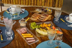 ein Holztisch mit Tellern mit Speisen und Weingläsern in der Unterkunft Pousada Maré Búzios in Búzios