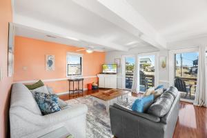 a living room with two couches and a tv at 6129 - Lady Jane in Nags Head