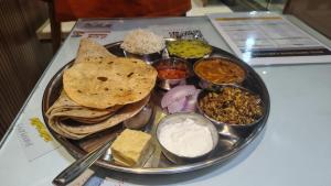 a plate of food with various foods on a table at Hotel ShivSundar Executive in Aurangabad