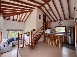 a kitchen and living room with wooden ceilings at Cabaña Villa Serena in Villa de Leyva