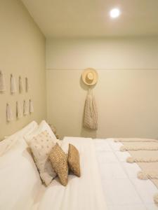 a bedroom with a white bed with a hat on the wall at Casa Magu Merida in Mérida