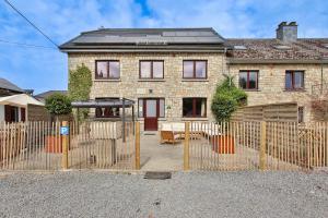a brick house with a fence in front of it at Le gîte l'écureuil in Malmedy