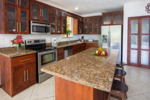 a kitchen with a island with a bowl of fruit on the counter at Casa de Fox - Confort en medio de la jungla! in Manuel Antonio