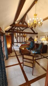 a bedroom with a bed and two chairs and a chandelier at Le Relais de la Tour in La Chaussée-Saint-Victor