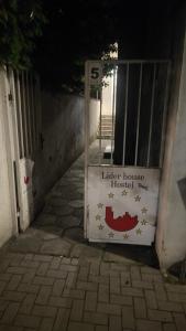 a sign for a lider house hospital next to a gate at Лидер Хаус хостел in Varna City