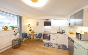a kitchen with white cabinets and a table and chairs at Ruhig Top mod Studio Appartement,privater Eingang in Oberhaching +29 photos