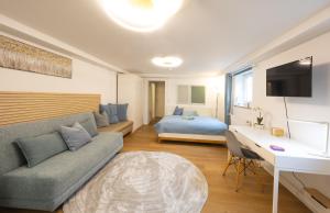 a living room with a couch and a bed at Ruhig Top mod Studio Appartement,privater Eingang in Oberhaching