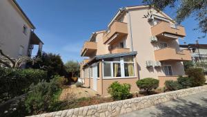 a building with a stone wall in front of it at Rooms-Sobe Haus Magdalena Krk in Krk