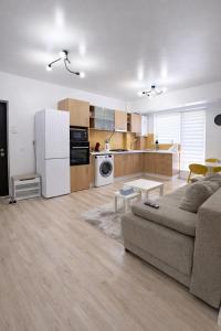a living room with a couch and a kitchen at Yellow Apartment in Floreşti