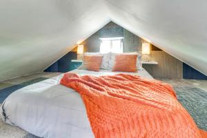 a bedroom with a bed with an orange blanket on it at Walk to Downtown! ABQ Couple's Studio w/ Deck in Albuquerque