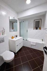 a bathroom with a sink and a toilet and a tub at Yellow Apartment in Floreşti +10 photos