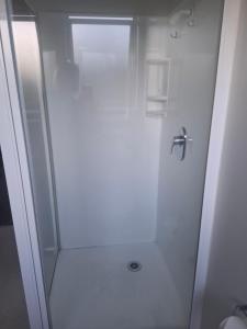 a white bathroom with a shower and a toilet at Aalton Motel Temuka in Temuka +9 photos