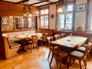 a restaurant with wooden tables and chairs and windows at Gasthof Sonne in Schiltach