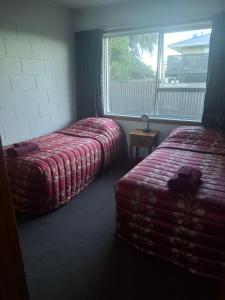 a hotel room with two beds and a window at Aalton Motel Temuka in Temuka