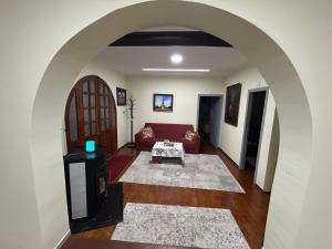 an archway in a living room with a red couch at Vila Spaho in Korçë
