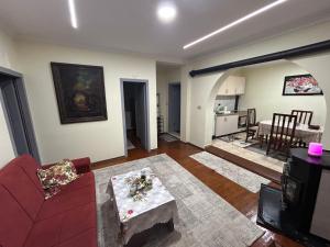 a living room with a red couch and a table at Vila Spaho in Korçë