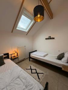 a bedroom with two beds and a window at Maison des Fées d'Achouffe in Houffalize