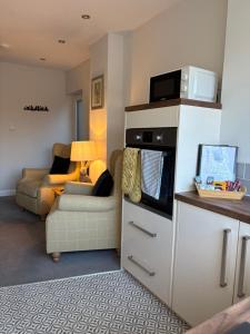 a living room with a couch and a microwave at The Nest - Worcester in Worcester
