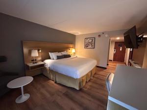 a hotel room with a large bed and a table at Urbana Hotel Conference Center in Urbana