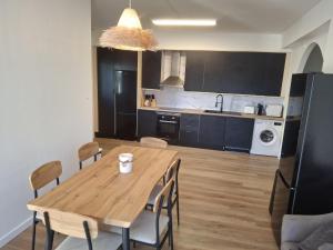 a kitchen and dining room with a wooden table and chairs at Marcemar in Borbén