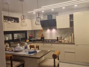 a kitchen with white cabinets and a counter top at Villa janna in Sukrah