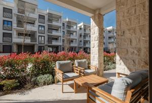 a patio with two chairs and a table and a building at River side apartment B3 in Herceg-Novi