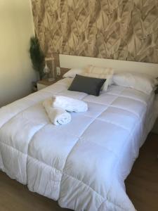 a large white bed with two stuffed animals on it at Marcemar in Borbén