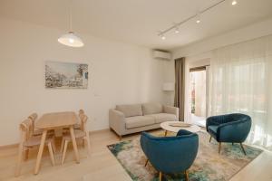 a living room with a couch and a table and chairs at River side apartment B3 in Herceg-Novi