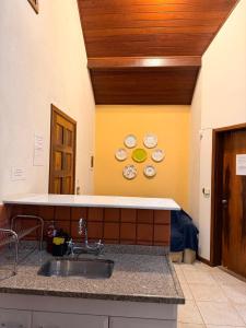a kitchen with a sink and plates on the wall at Recanto da Neblina in Monte Verde +10 photos