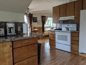 a kitchen with white appliances and wooden cabinets at Higgin's Inn in Powell River +30 photos
