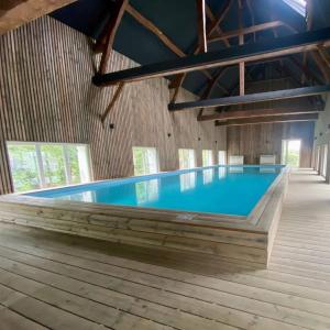 a large swimming pool in a building with a blue pool at Logis cosy avec piscine in Saint-Josse +12 photos