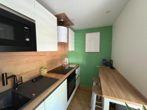 a kitchen with a sink and a microwave at Logis cosy avec piscine in Saint-Josse