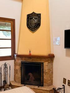 a fireplace with a clock on the wall at Recanto da Neblina in Monte Verde