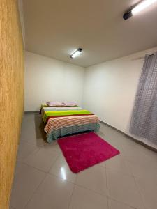 a room with a bed and a red rug at Hostel em SJC perto da rodoviária, centro,Embraer e cta in São José dos Campos +5 photos