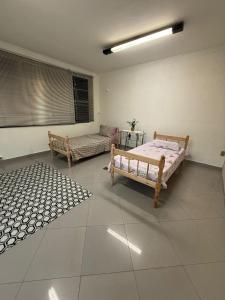 a bedroom with two beds and a rug at Hostel em SJC perto da rodoviária, centro,Embraer e cta in São José dos Campos