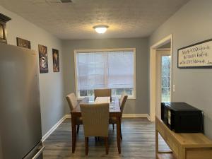 a dining room with a table and chairs and a refrigerator at Stylish 3BR Townhouse in Radcliff