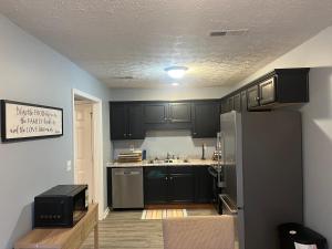 a kitchen with black cabinets and a refrigerator at Stylish 3BR Townhouse in Radcliff