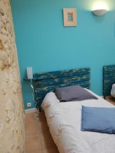 a bedroom with a bed with a blue wall at La Forge in Gignac +45 photos